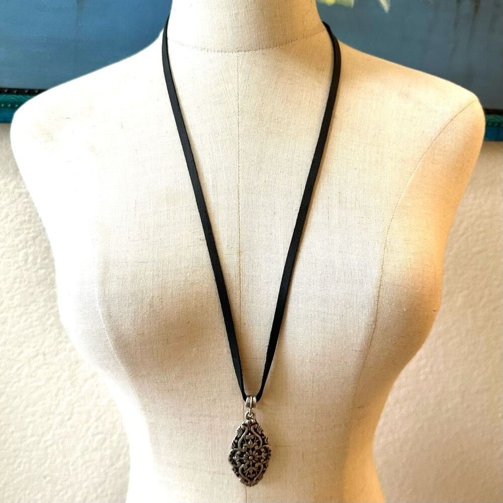 Silver tone pendant necklace on black cord